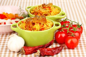 Delicious pilaf with vegetables on tablecloth background