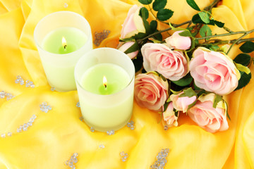 Candles on a yellow fabric close-up