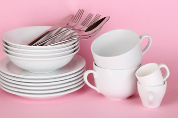Clean white dishes on pink background