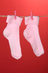 Colorful socks hanging on clothesline, on color background