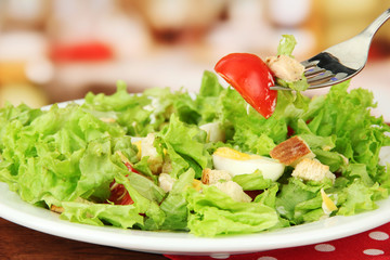 Caesar salad on white plate, close up on bright background