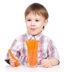 Little boy is eating carrot