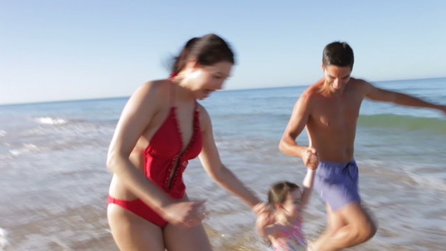 Family Running Along Beach
