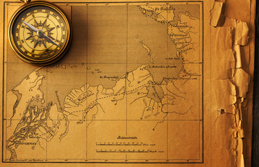 Antique compass over old map