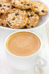 white cup of coffee with cookies