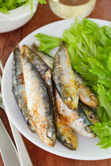 sardine with salad and glass of wine