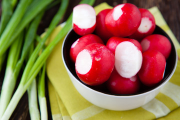 fresh red radishes and onions in a bowl