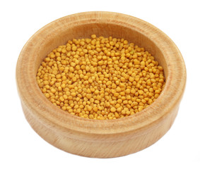 Fresh golden mustard on a wooden pot