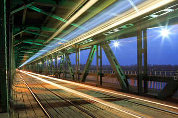 Tram in traffic on the bridge at night