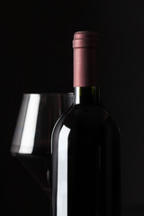 Bottle and glass with red wine.