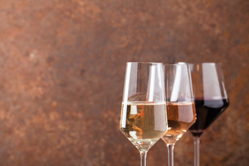 Three goblets with many types of wine.