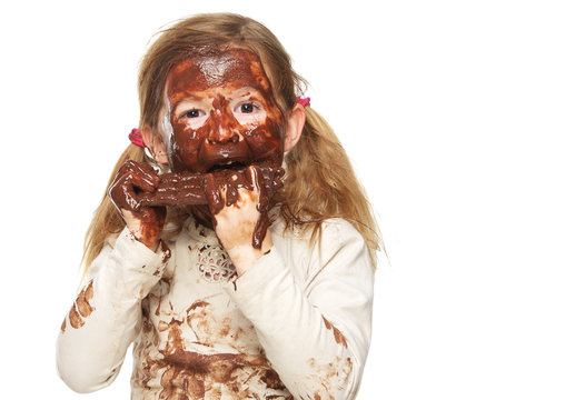 Little Girl Eating Chocolate Bar And Face Covered In Chocolate