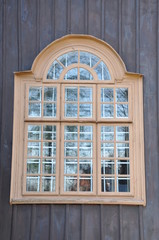 Arched window on wooden wall of house