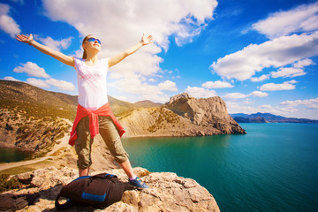 woman tourist is enjoying landscape with outstretched arms