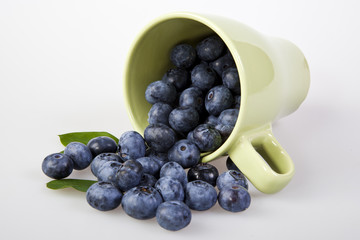 blueberries spilling from a cup