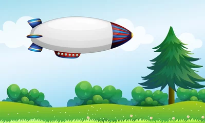 Photo sur Plexiglas Avion, ballon Un dirigeable au-dessus des collines