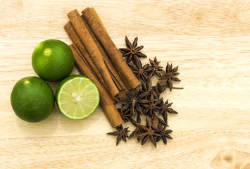 Anise and cinnamon with lime fruits on the chopping board.