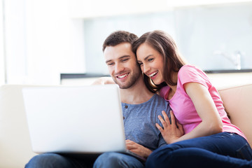 Fototapeta premium Couple on sofa with laptop