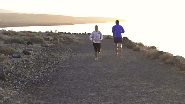 Young couple jogging on the beach, slow motion shot at 240fps 