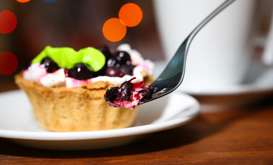 Tasty blackberry cake and cup of beverage,