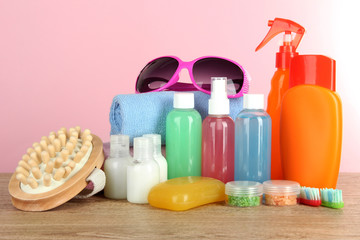 Hotel amenities kit on table on pink background