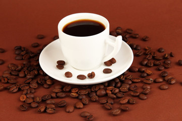 Cup of strong coffee on brown background