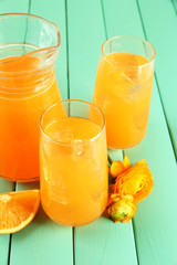 Glasses and pitcher of orange juice on blue wooden  background