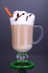 Layered coffee in glass on table on grey background