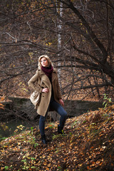 Young blond woman in autumn forest