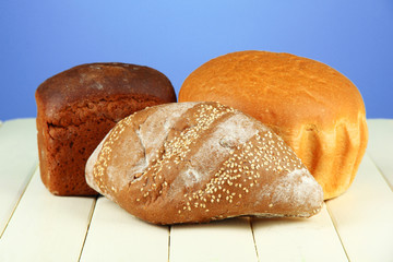 Composition with bread on wooden table, on color background