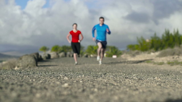 Young couple jogging on the beach, slow motion shot at 120fps 