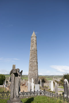 Angel statue before an Ancient round tower