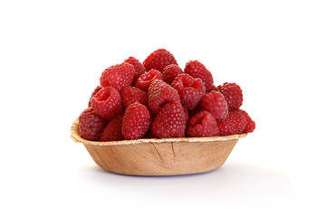 Fresh raspberries in the wooden platen isolated on white