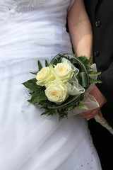 Ślubny bukiet kwiatów, biała suknia, dłonie.