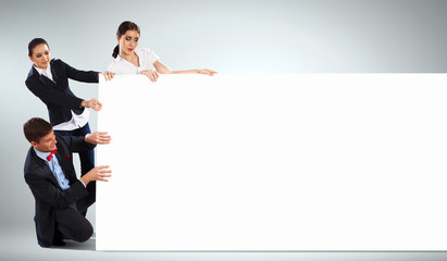 Three young people holding banner