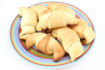 Fresh croissants on colored plate