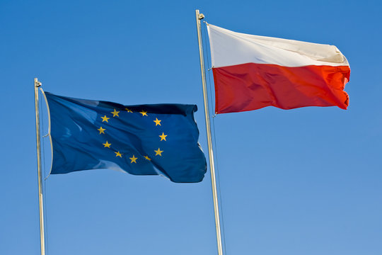 European union flag and a Polish flag on a background of sky
