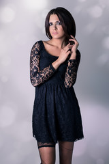 Fototapeta premium Very attractive young woman in black lace dress and black hose.