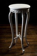Fototapeta na wymiar Round antique white table with carved legs