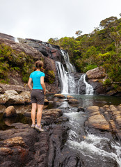 Trekker looks at wild waterfall in Horton Plains National Park,