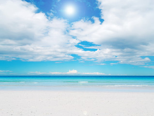 Fototapeta na wymiar biały piasek i błękitne niebo z słońca
