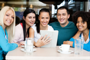 Happy group of teenagers with  tablet