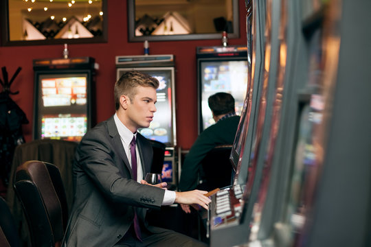 Young man playing the slot machine