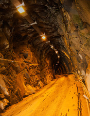 Obraz premium Ciemny tunel kopalniany ze światłami, pionowy - kamieniołom marmuru