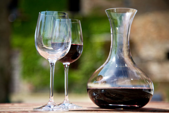 Red wine in a wine carafe and a two wine glasses in old vineyard