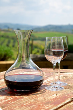 Red wine in a wine carafe and a two wine glasses in vineyard