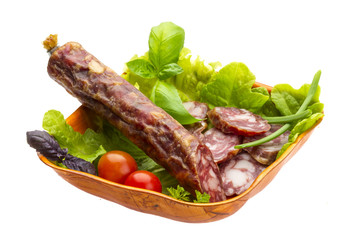 Ripe salami with salad, basil, onion and tomato