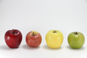 Four apples of different color against white background