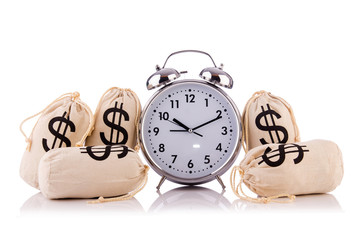 Sacks of money and alarm clock on white