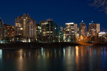 Fototapeta na wymiar Luxury condos at night along the Bow River in Calgary Alberta